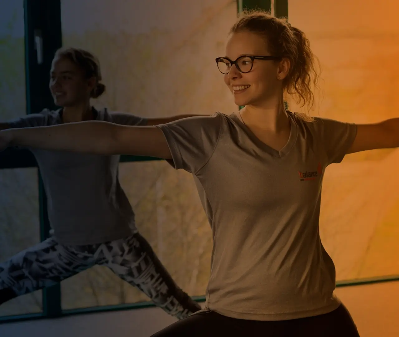 Fitnessstudio-Trainerin in gebrandetem Shirt beim Kurs – Bildsprache mit Wiedererkennungswert