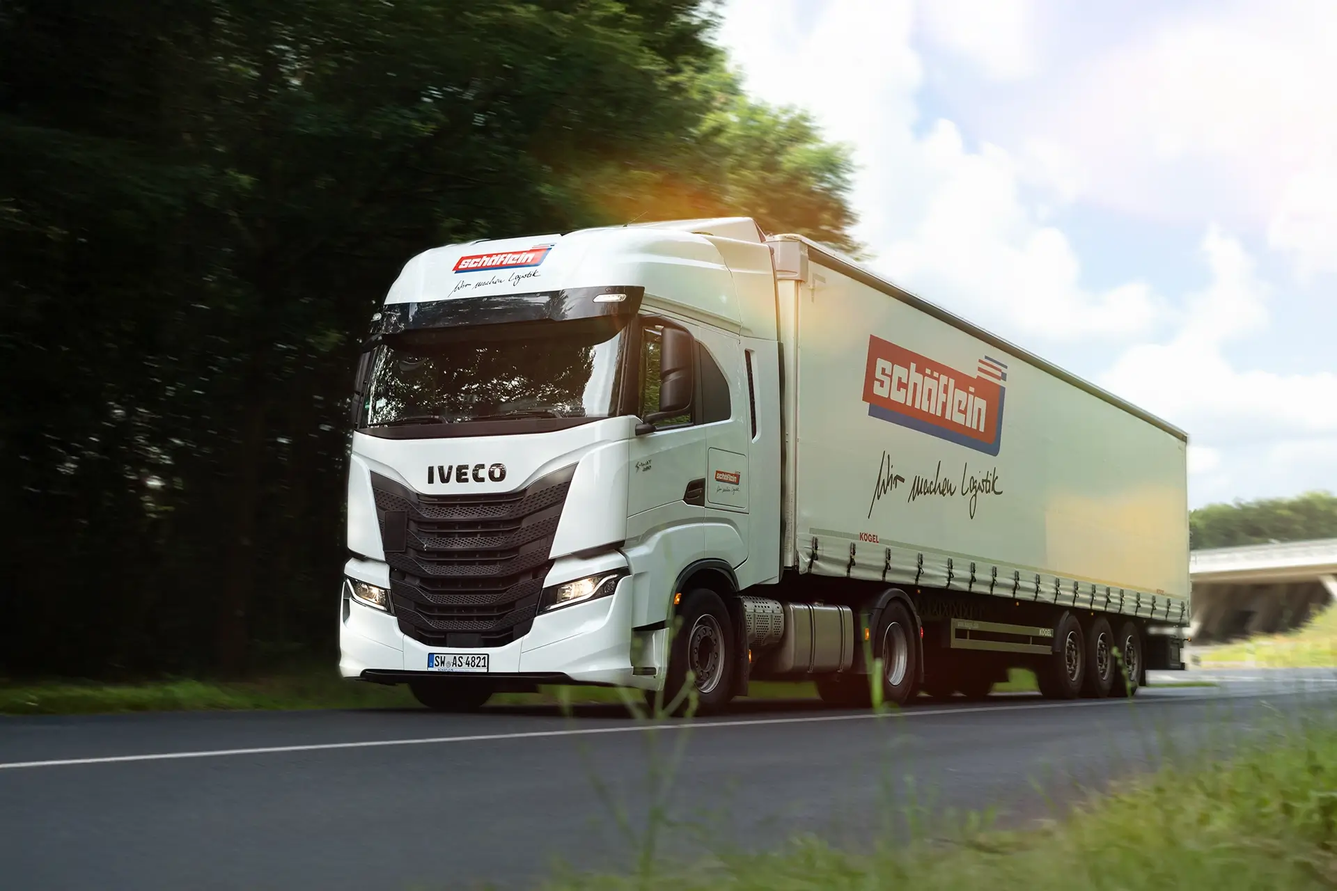 Corporate Design für Logistikunternehmen – LKW mit Fahrzeugbeschriftung der Schäflein AG bei der Fahrt.